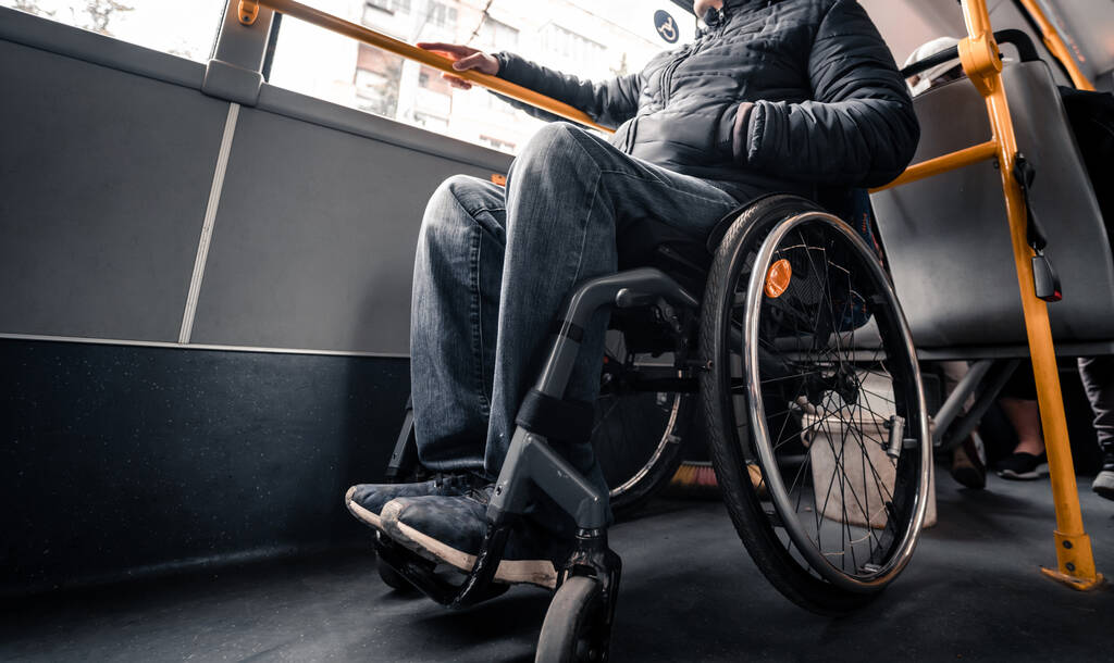 Persona con discapacidad física dentro del transporte público con una rampa accesible. - Foto, Imagen