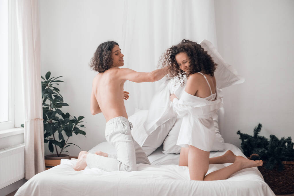 szczęśliwy heteroseksualny para mężczyzna i kobieta zabawy w łóżku - Zdjęcie, obraz