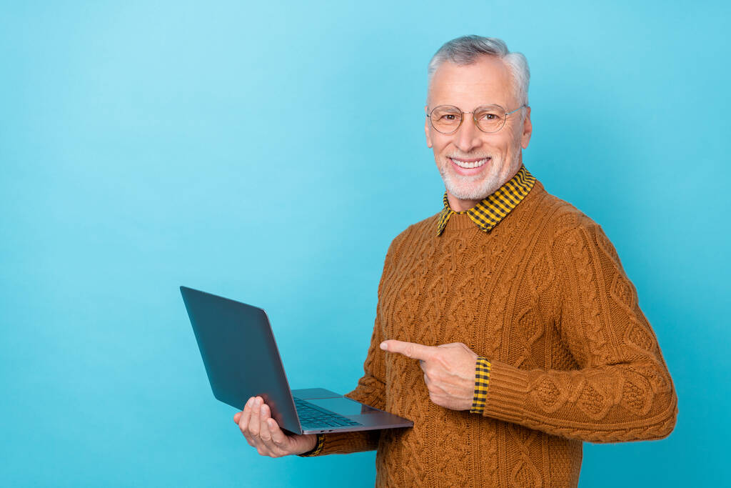 Photo of entrepreneur man point netbook present coworking digital promo wear pullover odizolowany niebieski kolor tła - Zdjęcie, obraz
