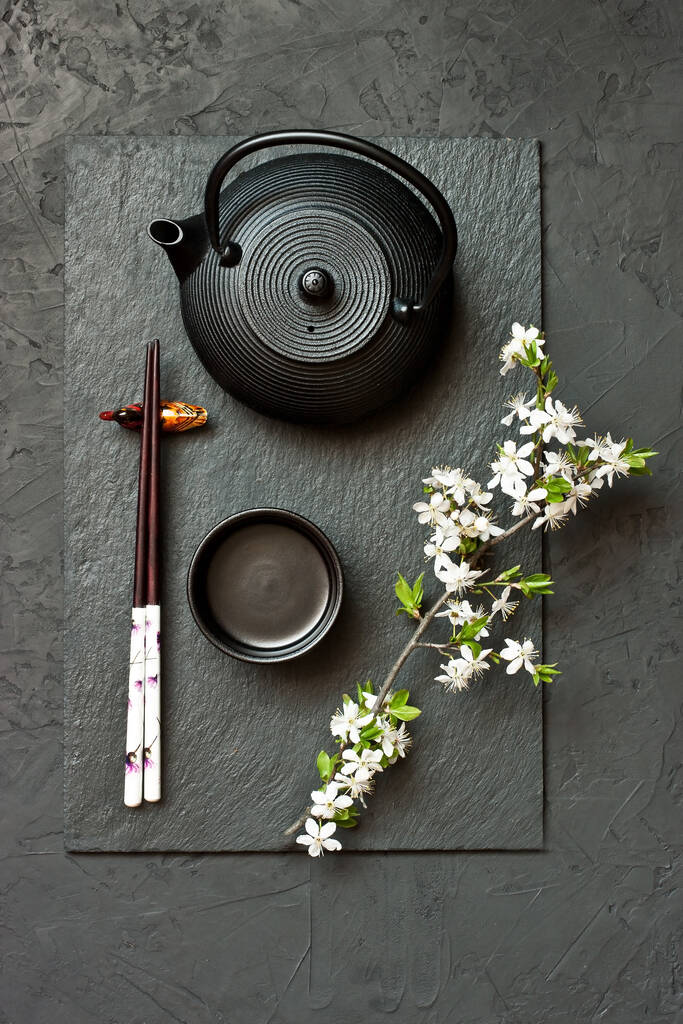 Ξύλινα ζεύγη ξυλάκια και κεραμικό πιάτο (πιάτο) σε σκούρο φόντο. Χώρος για κείμενο, εικόνα, διαφήμιση, μενού μαγειρικής σε ασιατικό στυλ - Φωτογραφία, εικόνα