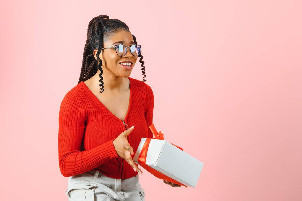 Foto van vrolijke positieve meisje houden geschenk pakket geïsoleerde roze kleur achtergrond. - Foto, afbeelding