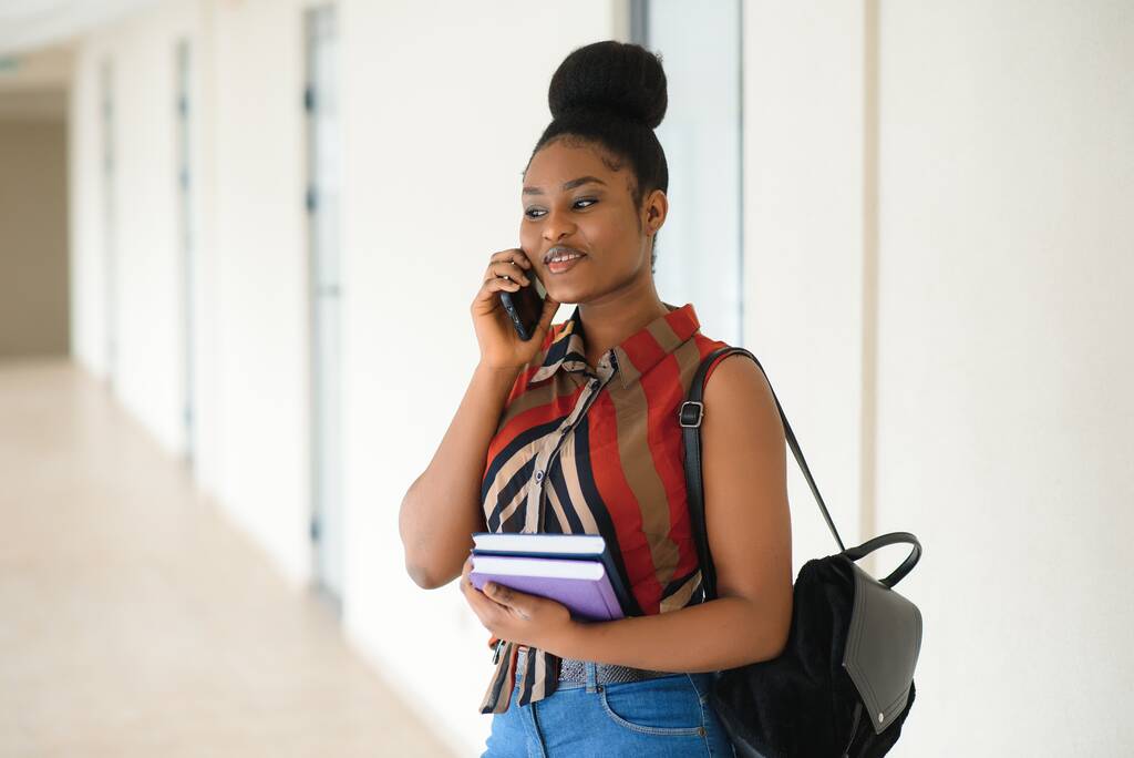 Nuori afrikkalainen amerikkalainen opiskelija tyttö hymyilee onnellinen kävely yliopiston kampuksella. - Valokuva, kuva