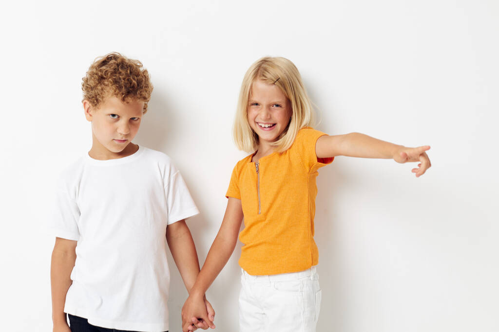 Leuke kleuterschool kinderen Vriendschap samen poseren emoties licht achtergrond houden handen - Foto, afbeelding
