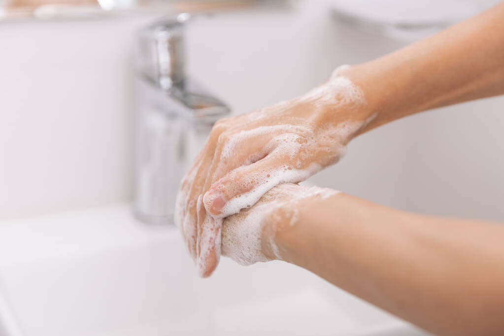Mycie rąk pod cieknącym kranem. Higiena koncept ręka szczegół. Mycie rąk mydłem w celu zapobiegania wirusom korony, higieny w celu powstrzymania rozprzestrzeniania się wirusa korony w publicznych myjniach - Zdjęcie, obraz