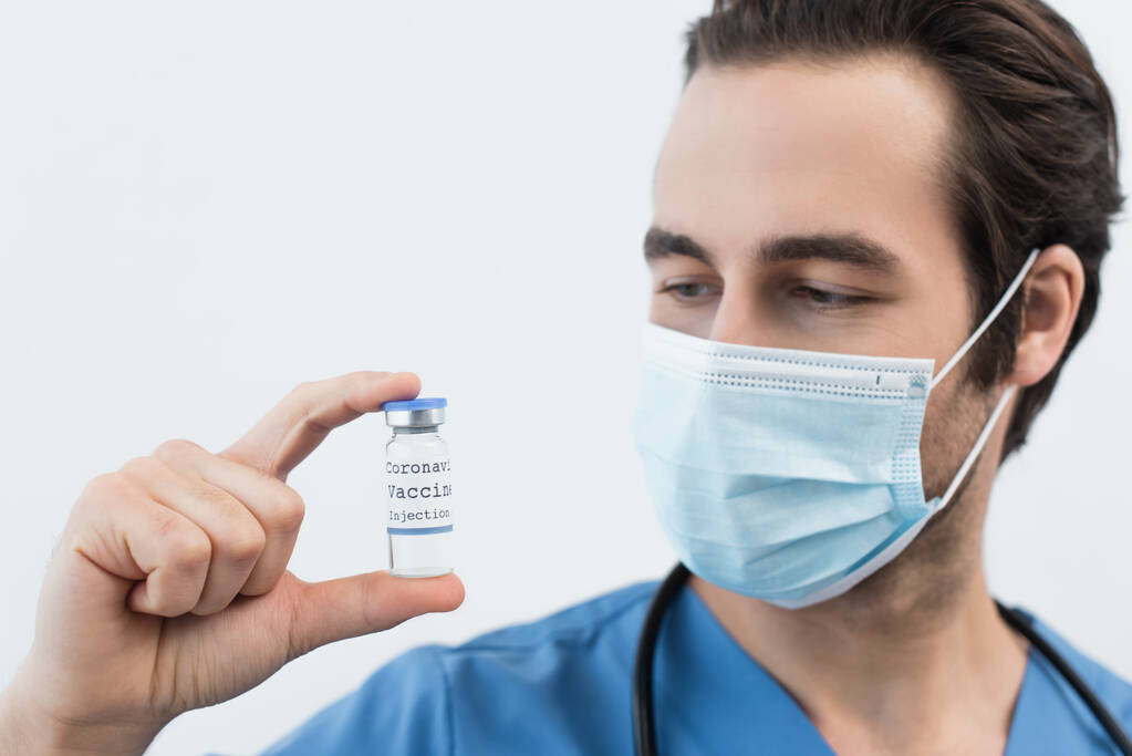 blurred doctor in medical mask holding coronavirus vaccine isolated on grey - Photo, Image