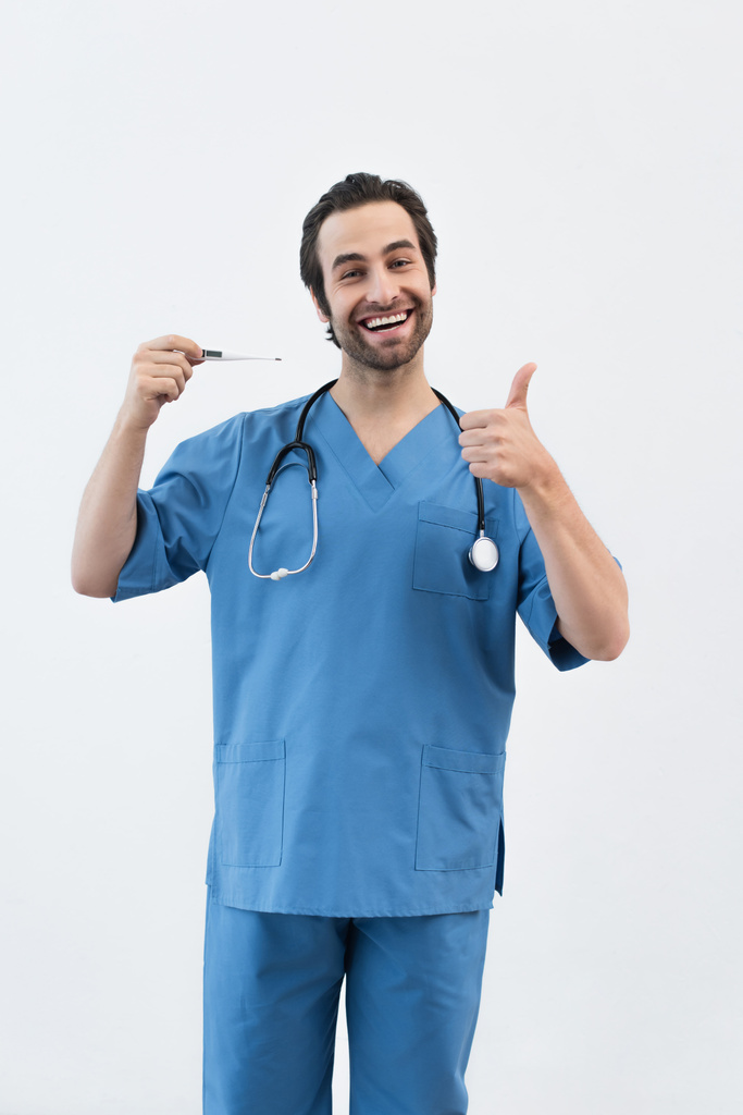 médico satisfeito com termômetro eletrônico mostrando polegar para cima isolado em cinza - Foto, Imagem