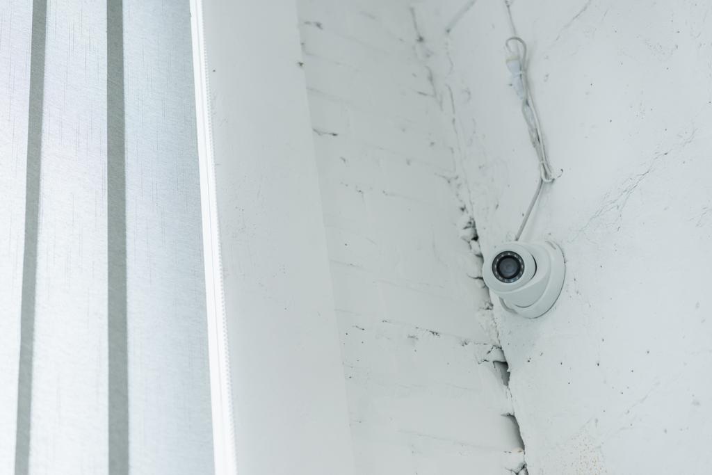 surveillance camera on white wall near corner - Photo, Image
