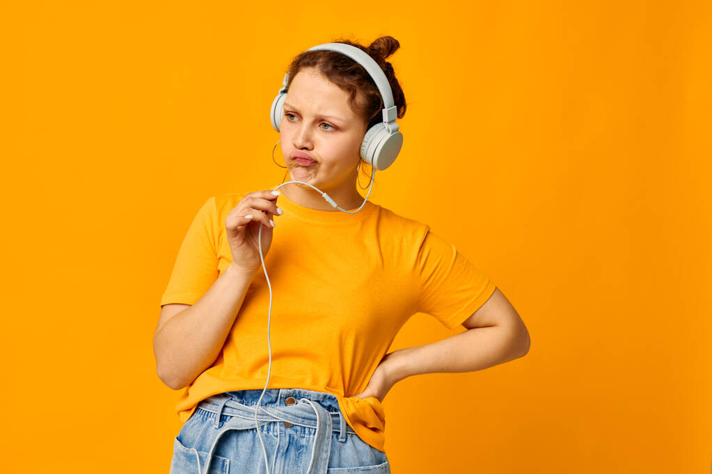 krásná žena poslech hudby na sluchátka styl mládeže žluté pozadí beze změny - Fotografie, Obrázek