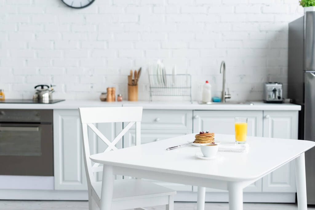 おいしいパンケーキ現代のキッチンで白いテーブルの上のコーヒーとオレンジジュース - 写真・画像