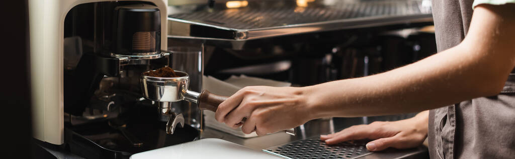 Обрізаний вид бариста, що тримає портативний фільтр біля кавомолки в кафе, банер
  - Фото, зображення