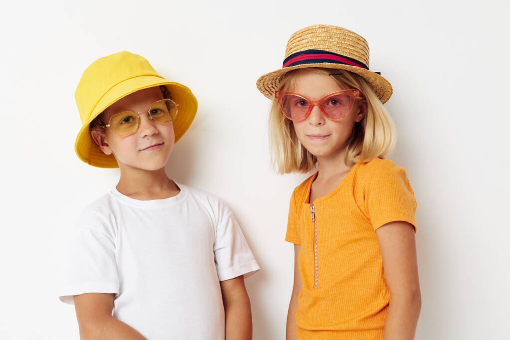 мальчик и девочка в шляпах очки моды, представляющие дружбу весело - Фото, изображение