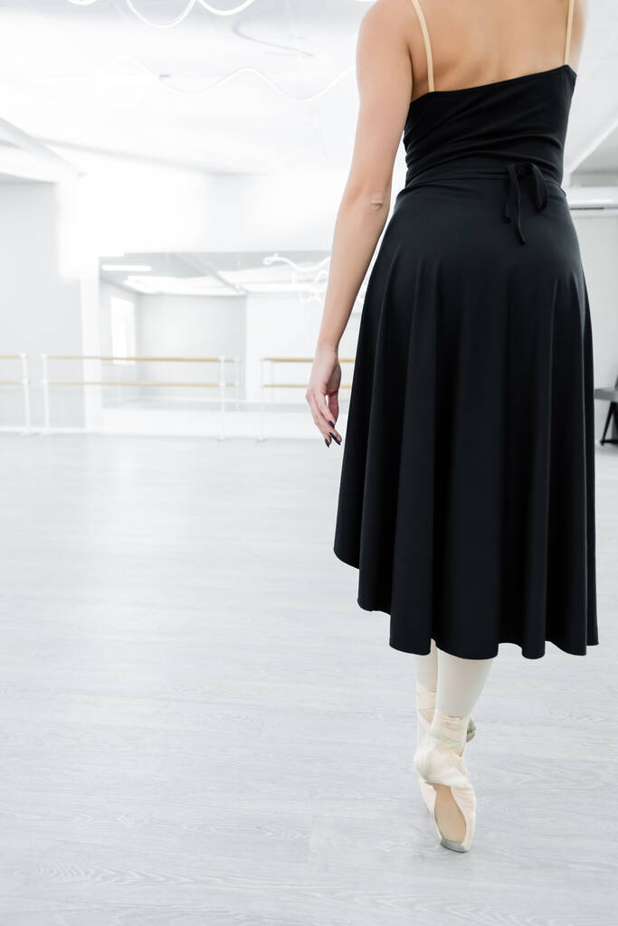 Siyah elbiseli balerinin arka plan görüntüsü stüdyoda prova yapıyor. - Fotoğraf, Görsel