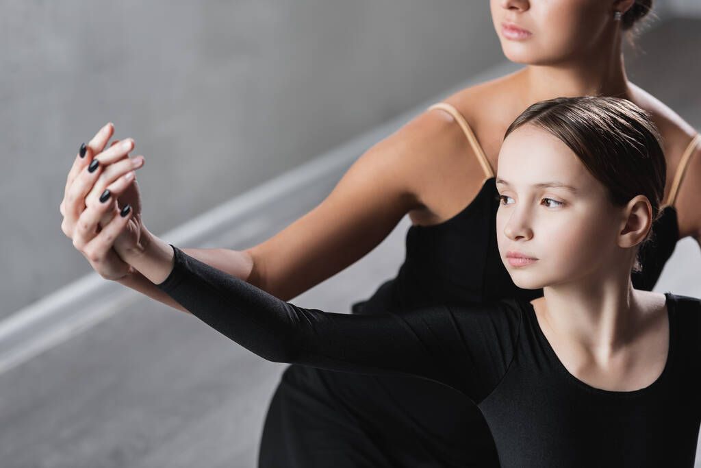 profesora de ballet cogida de la mano de una chica durante la clase de baile - Foto, imagen