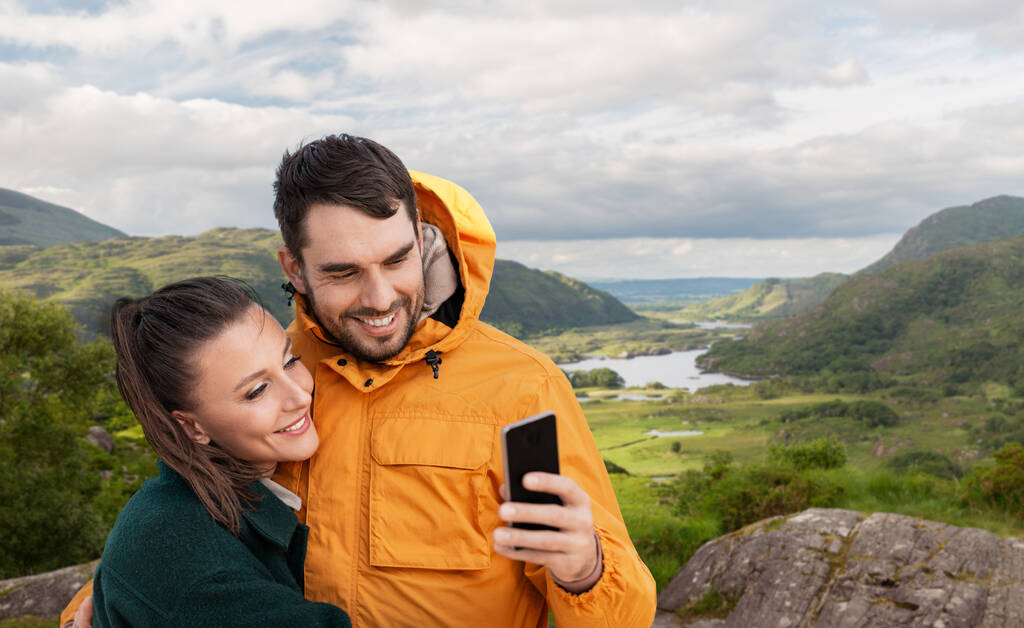 casal tomando selfie no telefone sobre paisagem irlandesa - Foto, Imagem