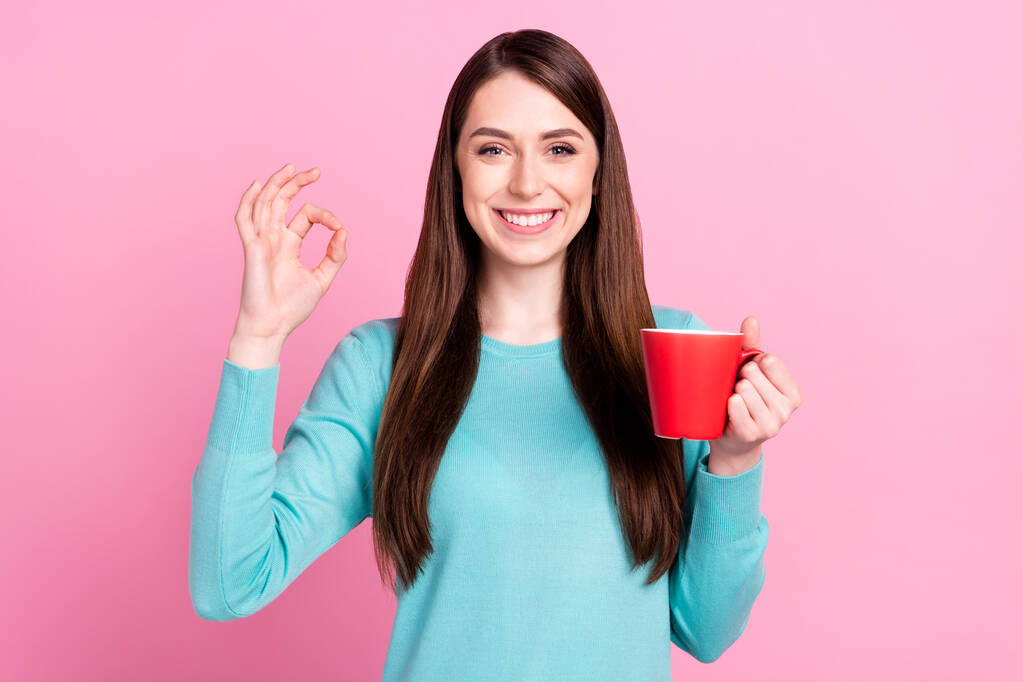 Fényképezés portré lány tartása kávésbögre bemutató oké gesztus elszigetelt pasztell rózsaszín háttér - Fotó, kép