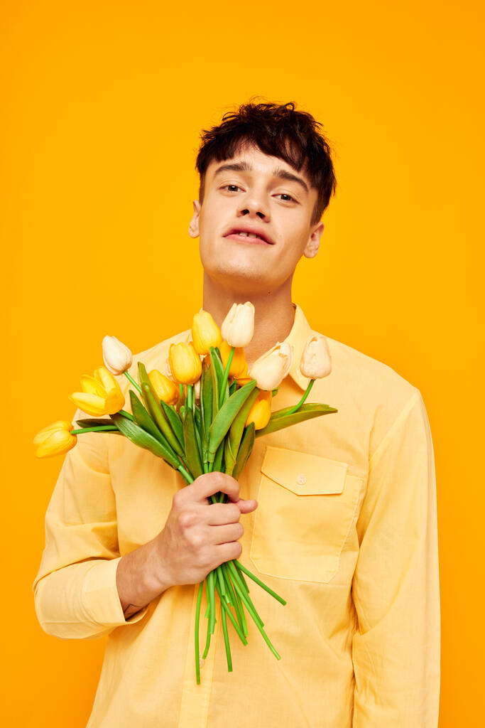 przystojny facet w żółtych okularach z bukietem kwiaty odizolowane tło bez zmian - Zdjęcie, obraz