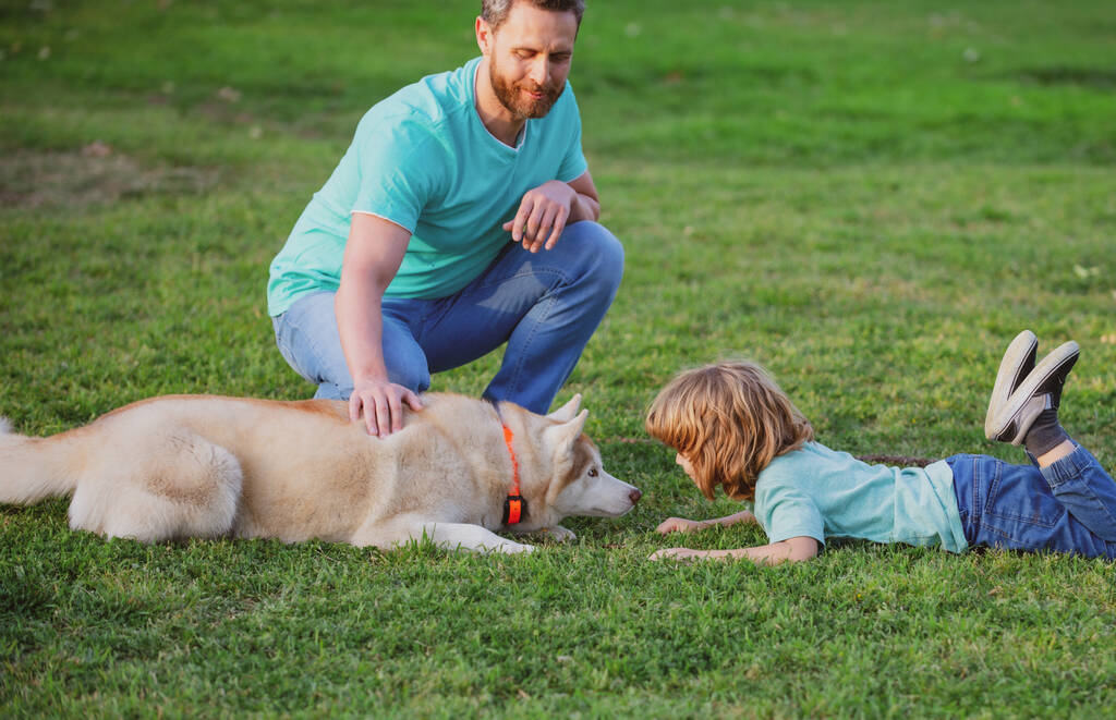 Child with pet friend. Father and son with dog spending time outdoor. - Photo, Image