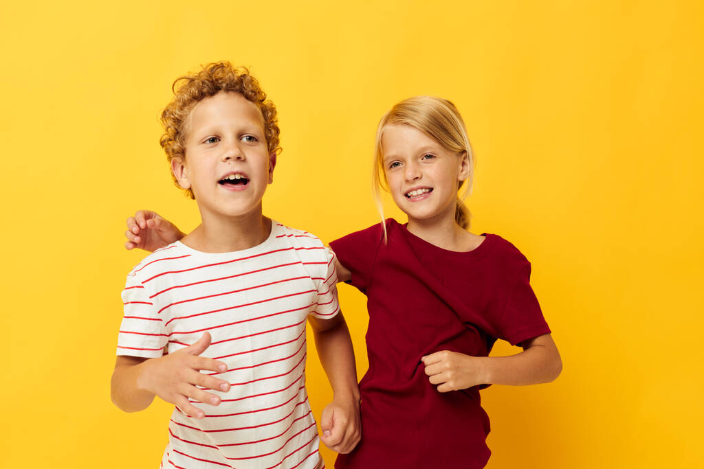 Bild von positiven Jungen und Mädchen Freizeitkleidung Spiele Spaß zusammen auf farbigem Hintergrund - Foto, Bild