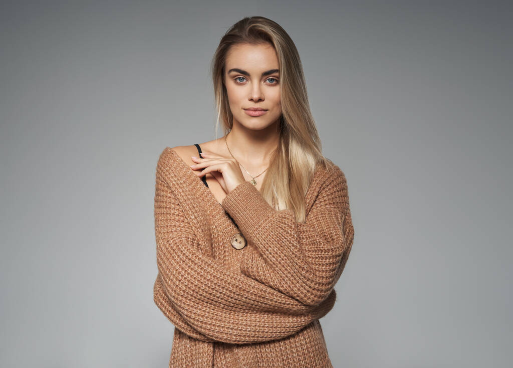 Retrato de cerca de una joven rubia en suéter de lana marrón - Foto, imagen
