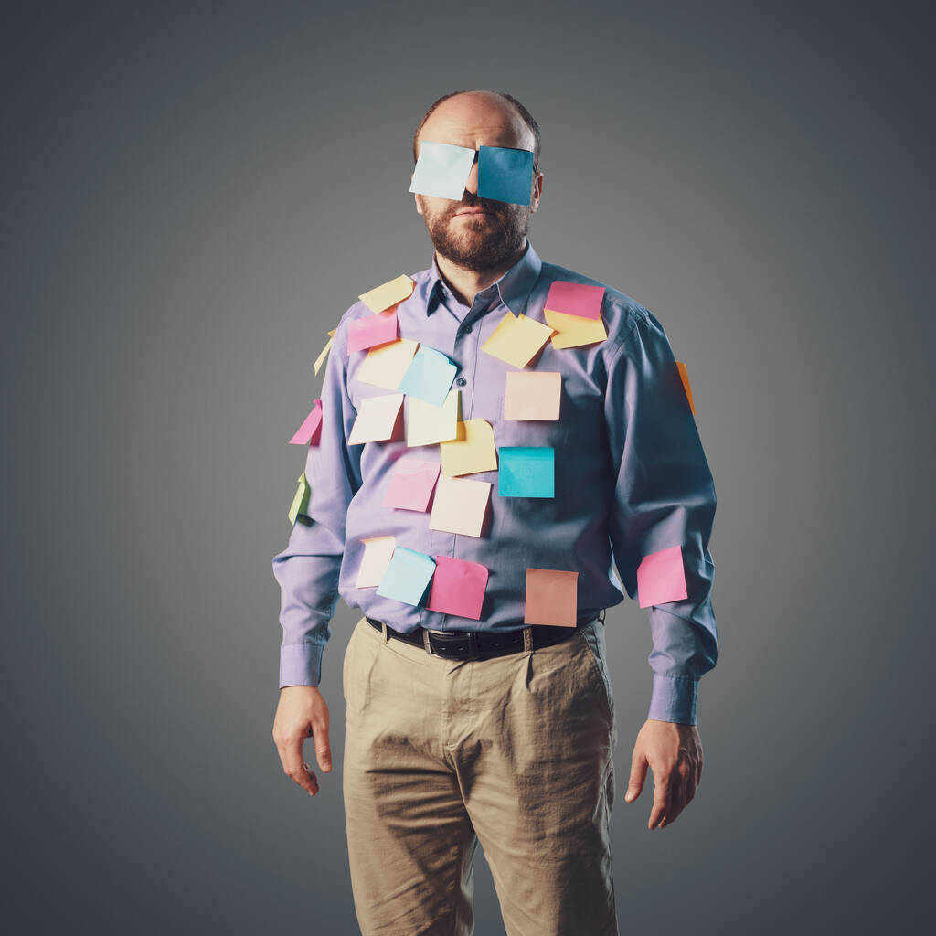 Funny businessman covered with sticky notes, he is looking at camera - Photo, Image