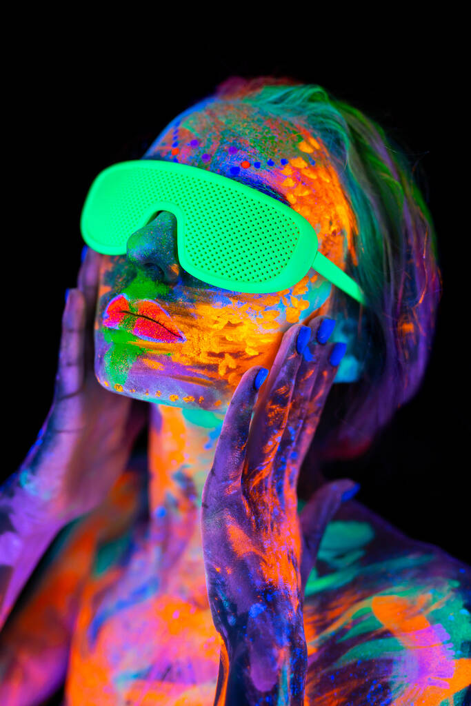 Krásná modelka nosí brýle s pestrobarevným zářivkovým make-upem v neonovém světle, diskotéka nočního klubu - Fotografie, Obrázek