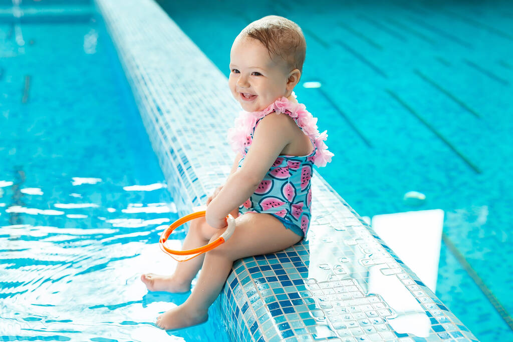 Bambina sta ridendo in piscina a una lezione di nuoto - Foto, immagini