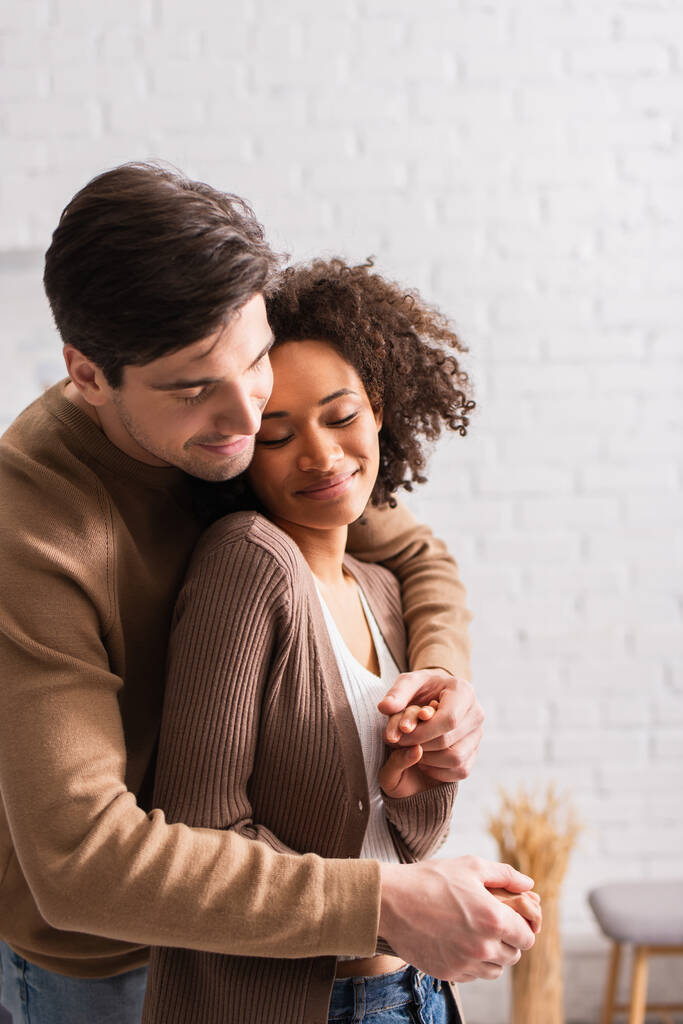 Man hugging pretty african american girlfriend at home  - Photo, Image