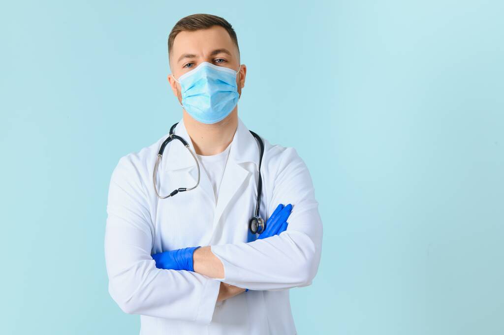 男性医師で医療マスク上の色の背景 - 写真・画像