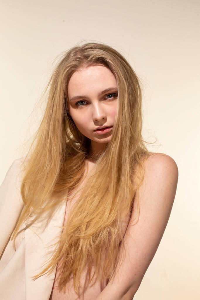 Junge Frau mit blonden Haaren isoliert auf beige - Foto, Bild