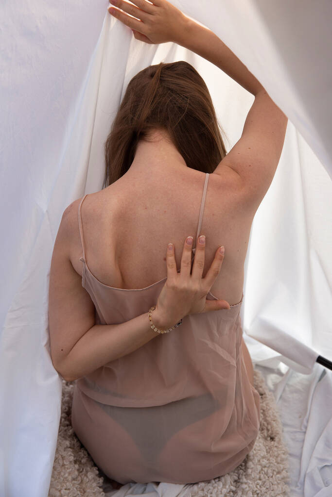 Zurückgekehrte junge Frau mit weißen Hautvorhängen im Hintergrund - Foto, Bild