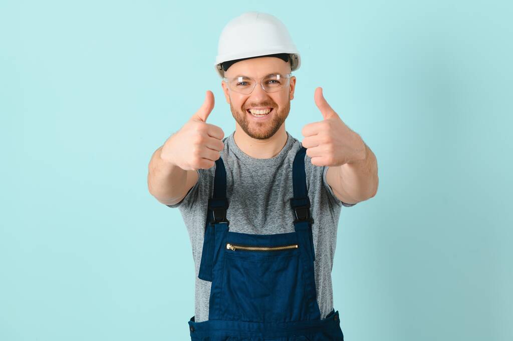 Artesãos ou eletricista homem sobre fundo azul isolado dando um gesto polegares para cima - Foto, Imagem