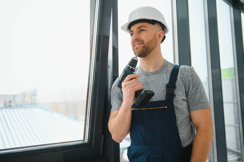 hombre de servicio instalando ventana con destornillador - Foto, Imagen