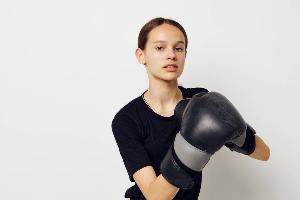 красивая девушка в черной спортивной форме боксерские перчатки, позируя стиль жизни неизменным - Фото, изображение