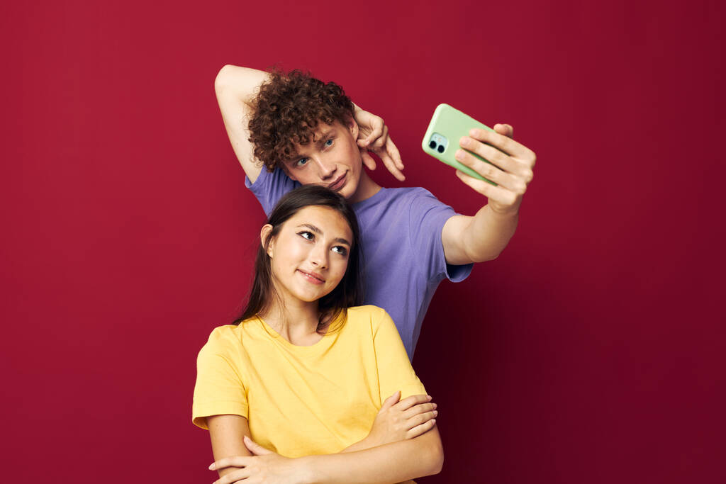 mladý muž a dívka vzít selfie představovat objetí izolované pozadí - Fotografie, Obrázek