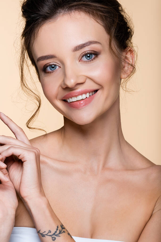 Happy young woman looking at camera isolated on beige  - Photo, Image