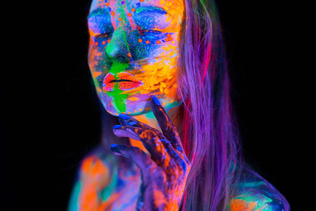 ネオンライトの美しい若い女性。UV光の中でカラフルなメイクでポーズをとる蛍光メイクモデルの肖像. - 写真・画像