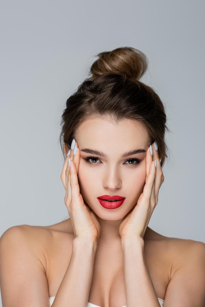 charming woman with perfect skin and red lips looking at camera isolated on grey - Photo, Image