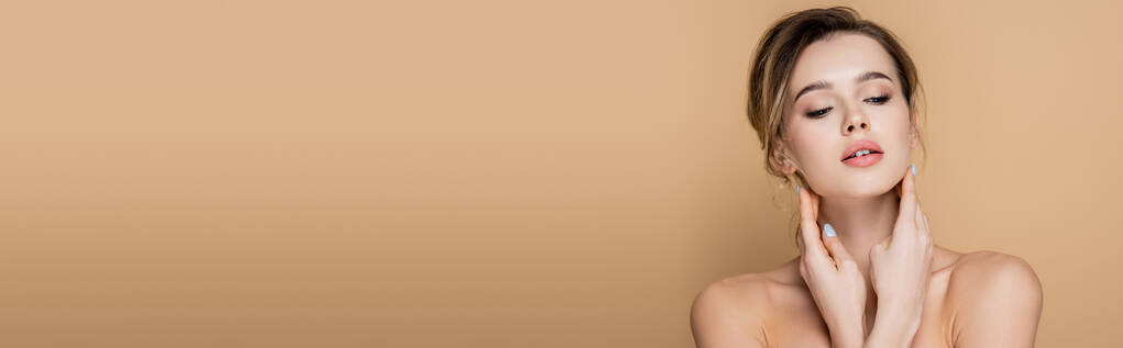 mujer sensual con la piel perfecta y hombros desnudos posando aislado en beige, bandera - Foto, imagen