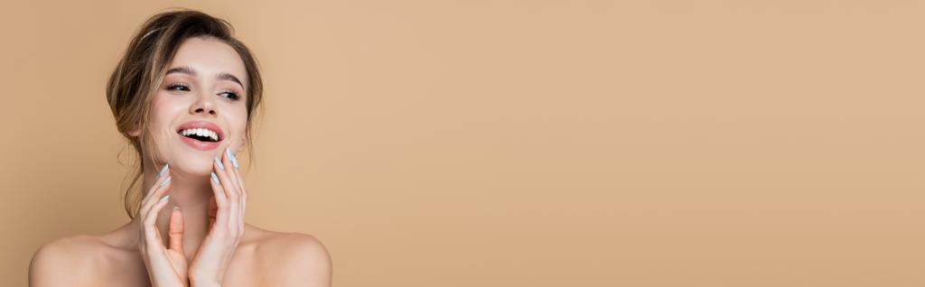iloinen nainen paljain hartioin ja täydellinen iho etsii pois eristetty beige, banneri - Valokuva, kuva