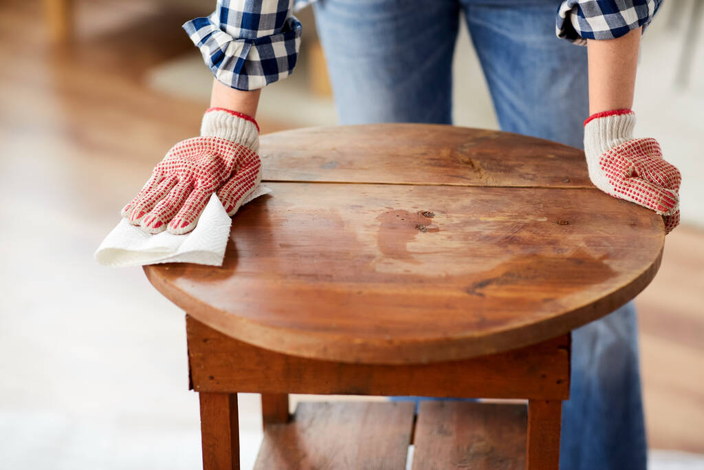 woman cleaning old table surface with paper tissue - Photo, Image