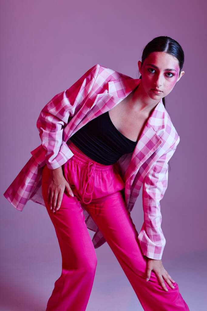 Молодая красивая женщина клетчатый пиджак моды, представляя роскошь розовый фон без изменений - Фото, изображение