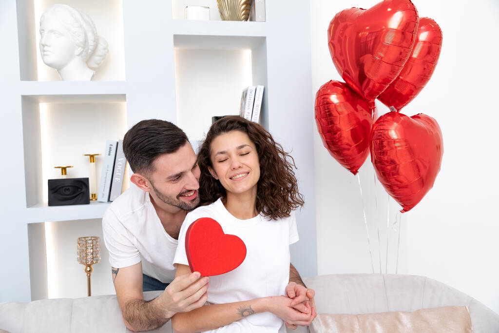 een man en vrouw verheerlijkt het geschenk voor Valentijnsdag  - Foto, afbeelding