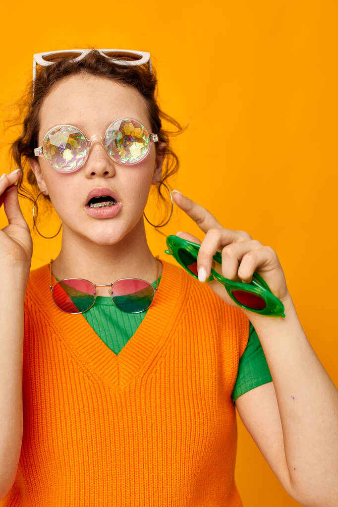 portrét mladé ženy oranžové mikiny sluneční brýle pestrobarevné brýle zásobování životní styl beze změny - Fotografie, Obrázek