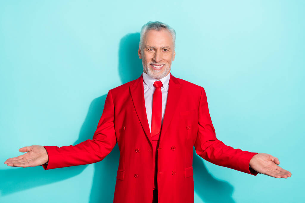 Photo of cute retired man wear red three piece suit comparing arms empty space isolated turquoise color background - Photo, Image