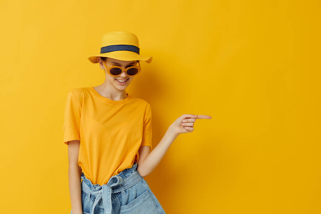 красивая девушка в желтой шляпе Молодежный стиль повседневной одежды в солнцезащитных очках - Фото, изображение