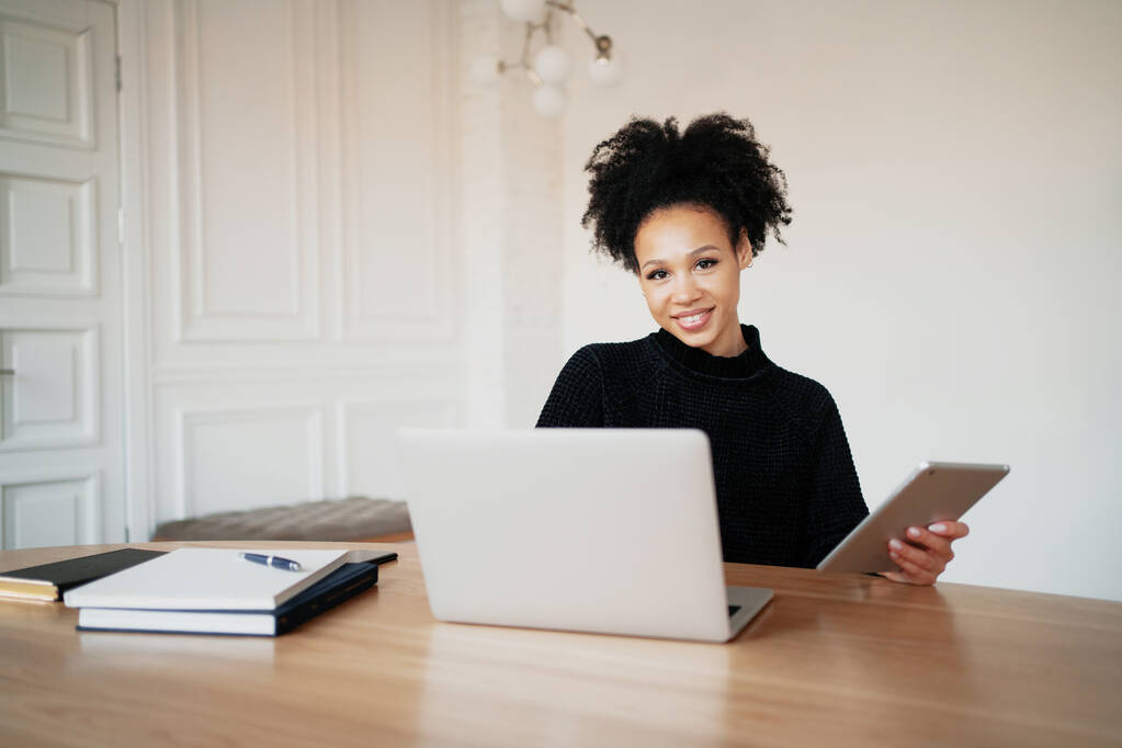 Afro görünümlü hoşnut bir kadın. Bir kadın çevrimiçi takılıyor. - Fotoğraf, Görsel