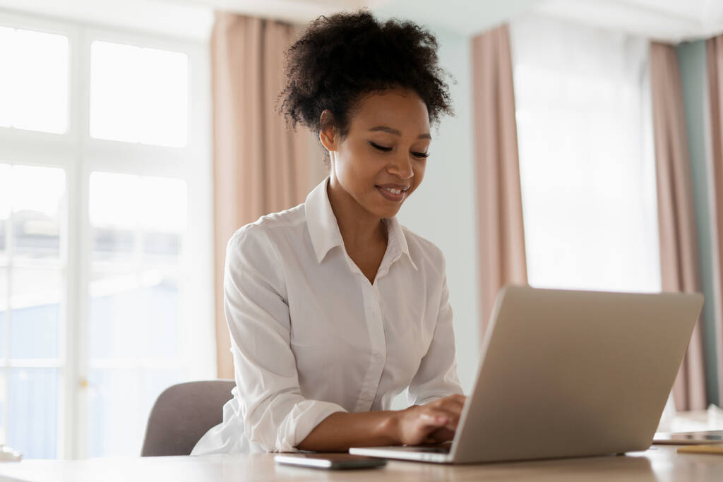 Leerling thuis online leren. Een vrouw die op internet surft. De blogger werkt aan een laptop. Werkplaats in de keuken. Een freelancer print een bericht naar klanten op een sociaal netwerk. - Foto, afbeelding