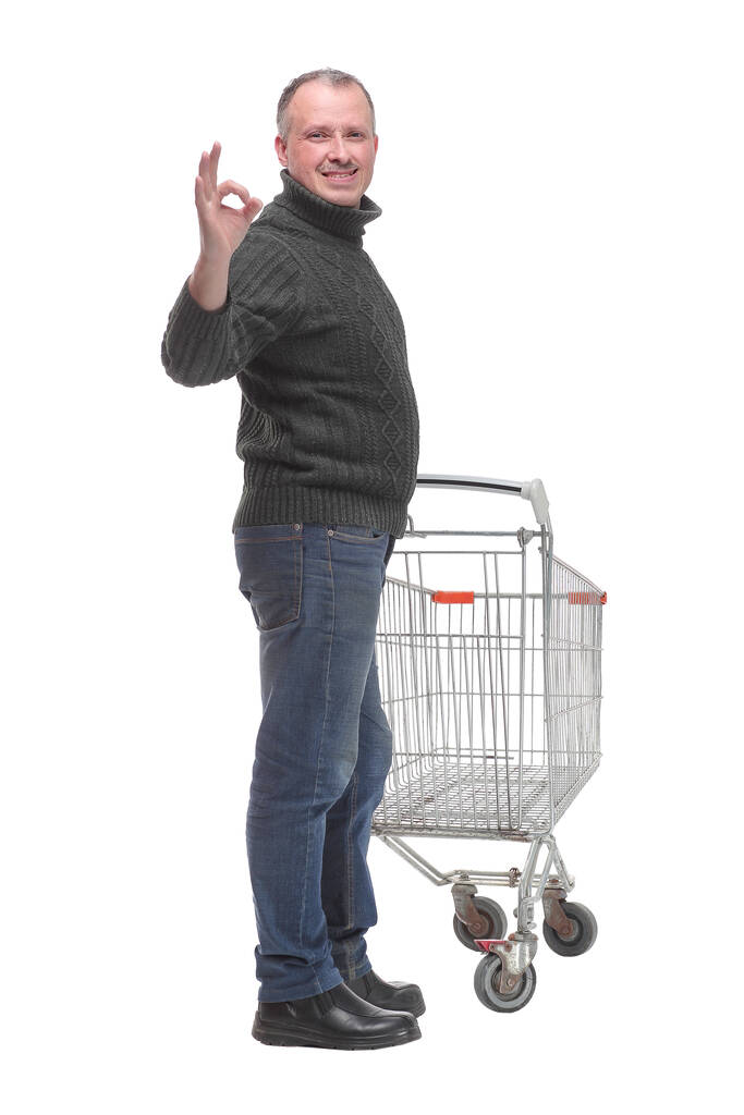 Hombre con carrito de compras mostrando signo ok aislado sobre fondo blanco - Foto, imagen