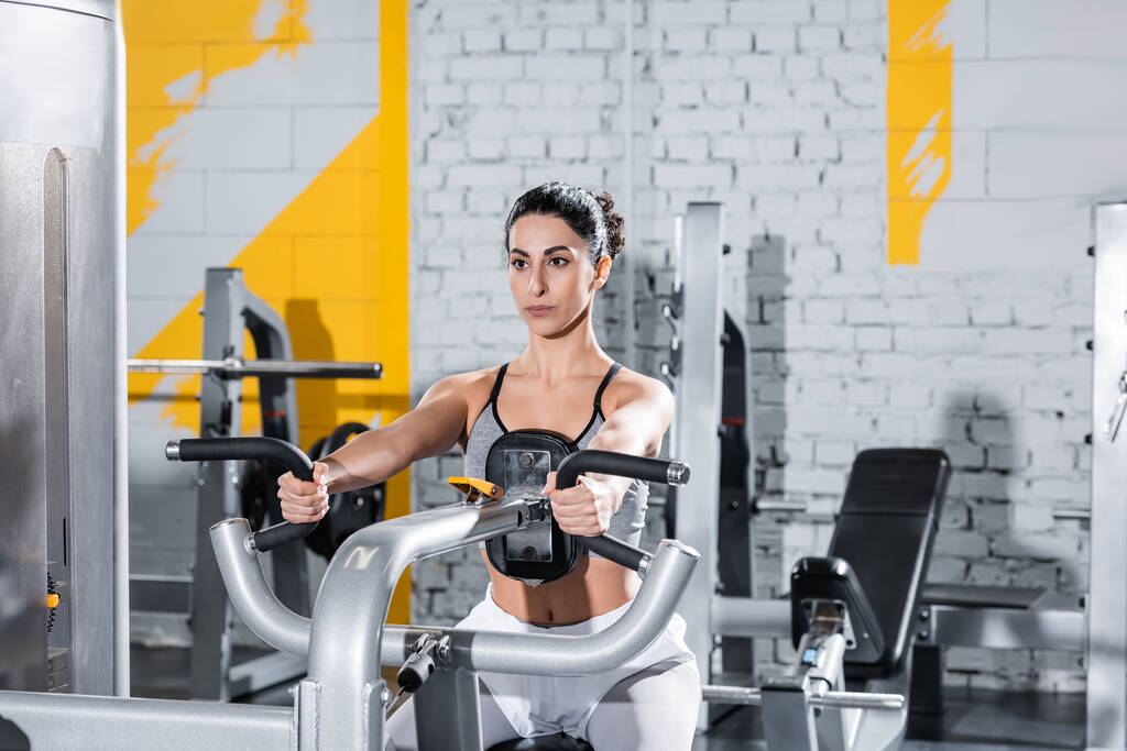 Moyen-Orient sportive travaillant avec ab crunch machine dans la salle de gym   - Photo, image
