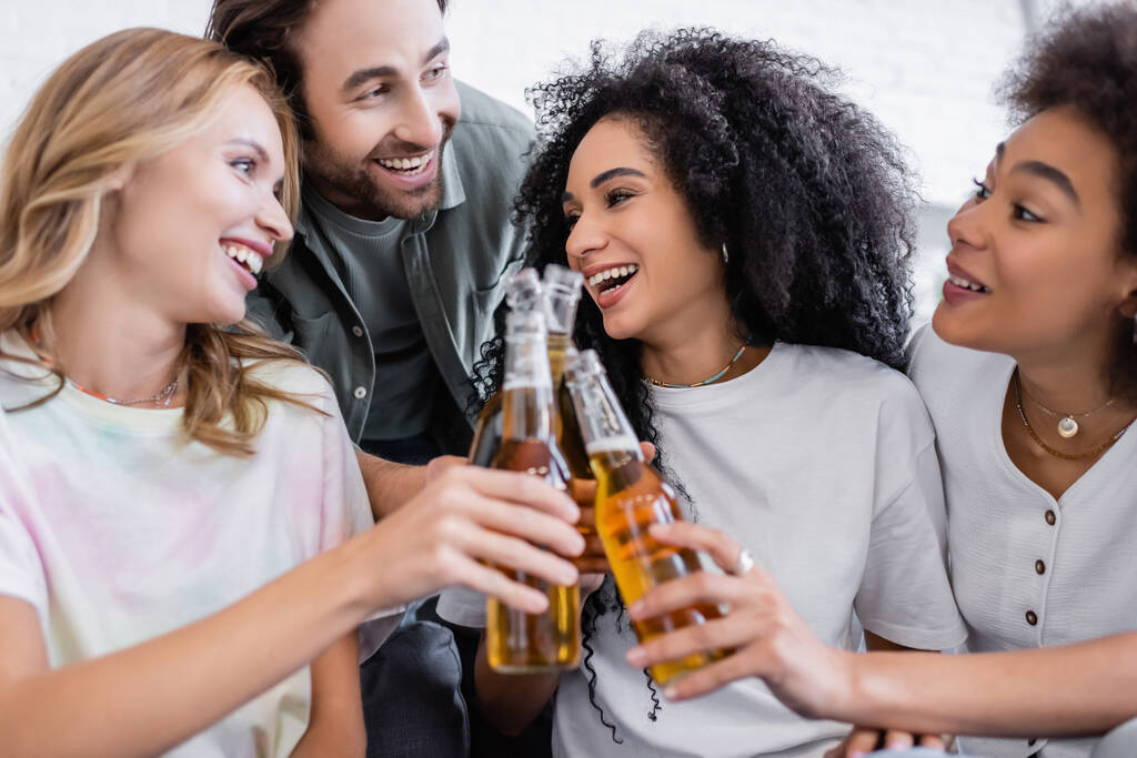 幸せな男と楽しい異人種間の女性がビールを飲みながら  - 写真・画像